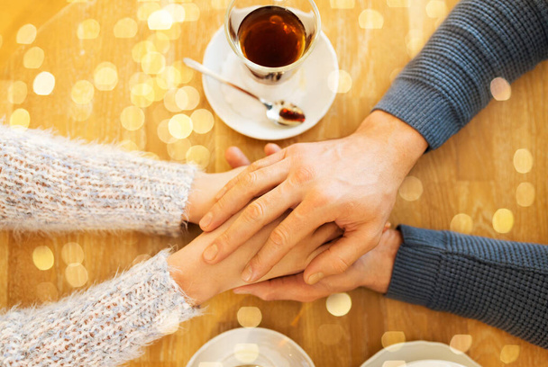 close up of couple holding hands at restaurant - Fotografie, Obrázek