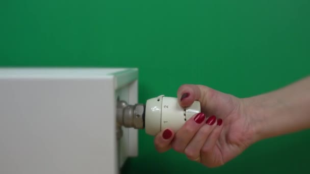 kéz csökkenti a meleg radiátor termosztát zöld háttér. 4K - Felvétel, videó