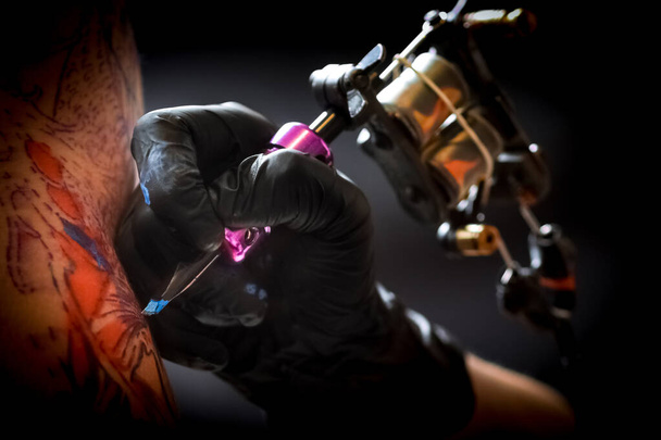 男性の腕にタトゥーを作る女性タトゥー アーティスト - 写真・画像