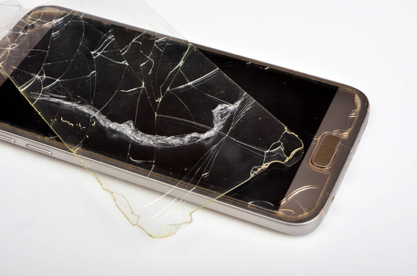 Σπασμένο προστατευτικό γυαλί στο φόντο του τηλεφώνου - Φωτογραφία, εικόνα
