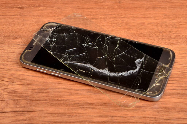携帯電話の背景に壊れた保護ガラス - 写真・画像