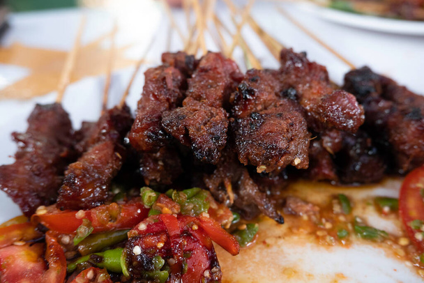 Yksi tyypillisesti indonesialainen ruoka on satany tai sate. Tämä ruoka on valmistettu naudan- tai lampaanlihasta tai kanasta, joka grillataan savuisten hiilien päälle ja tarjoillaan sitten maapähkinäkastikkeen ja soijakastikkeen kanssa.. - Valokuva, kuva