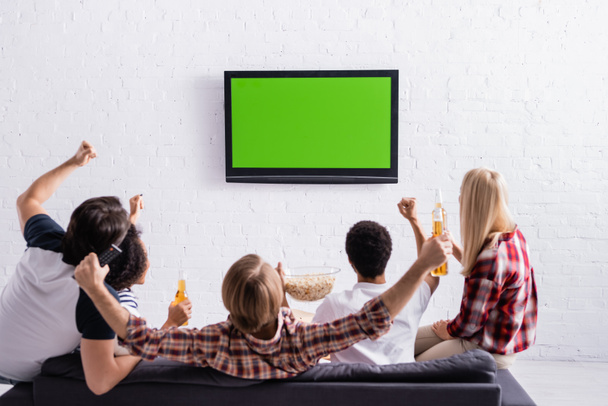 visão traseira de fãs de esportes multiculturais animado mostrando gesto de vitória enquanto assiste campeonato na tv - Foto, Imagem