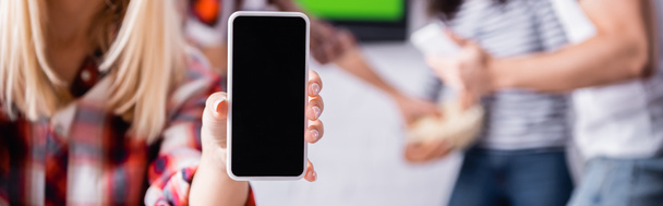przycięty widok kobiety trzymającej smartfona z pustym ekranem w pobliżu przyjaciół na rozmytym tle, baner - Zdjęcie, obraz