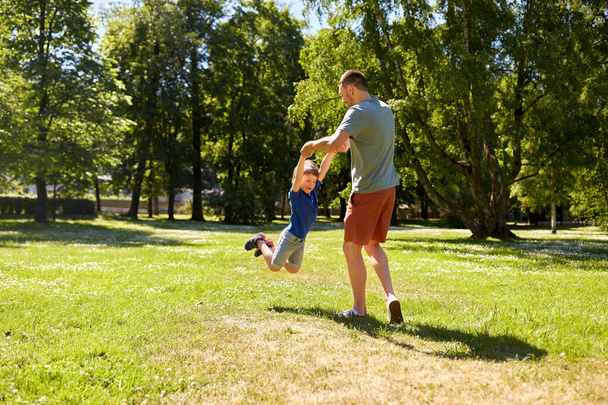 happy father with son playing in summer park - Foto, immagini