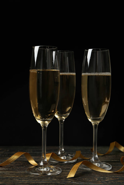 Copas de champán y cintas rizadas sobre mesa de madera - Foto, Imagen