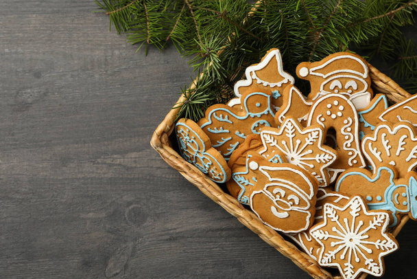 クリスマスクッキーと暗いテーブルの上に松の枝とバスケット - 写真・画像
