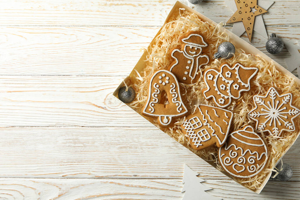 Κουτί με χριστουγεννιάτικα μπισκότα σε λευκό ξύλινο φόντο - Φωτογραφία, εικόνα