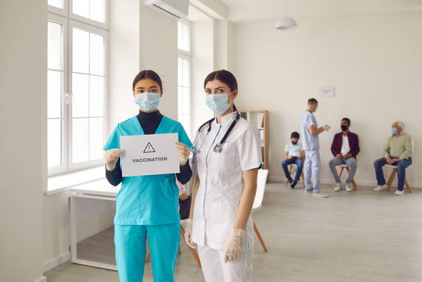 Young doctors in medical face masks promoting vaccination campaign that saves lives - Fotografie, Obrázek