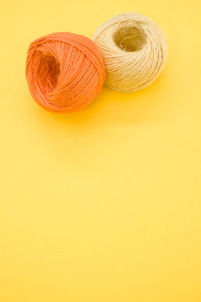 A vertical shot of yarn balls for knitting isolated on yellow background - Photo, Image