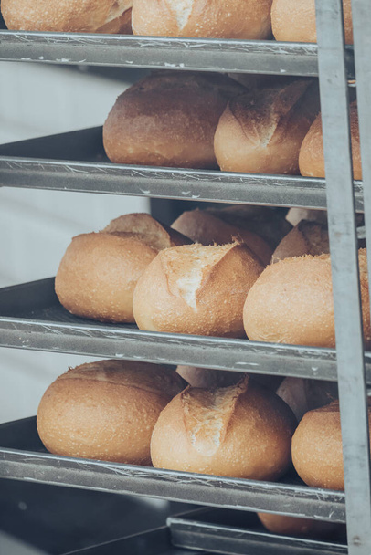 A closeup shot of freshly baked bread in handcart from oven - Fotó, kép