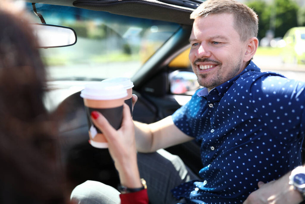 Smiling man drinks drinks with a woman in car. - Foto, Imagem
