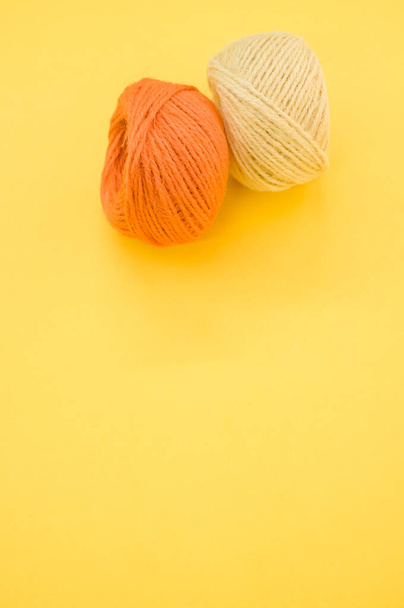 A vertical shot of yarn balls for knitting isolated on yellow background - Zdjęcie, obraz