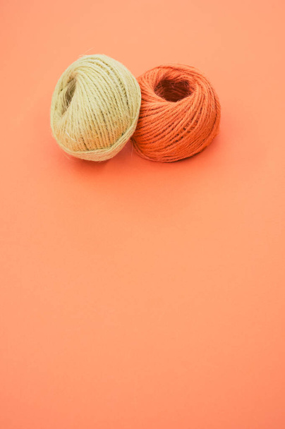 A vertical shot of yarn balls for knitting isolated on orange background - 写真・画像