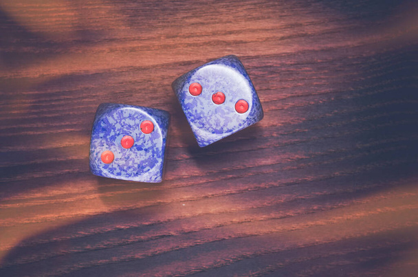 An overhead shot of two dice on a wooden surface - Фото, изображение