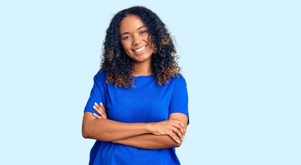 Young african american woman wearing casual clothes happy face smiling with crossed arms looking at the camera. positive person.  - Photo, Image
