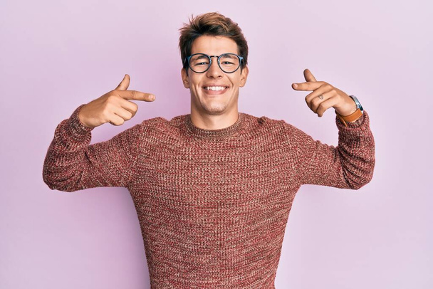Красивый белый мужчина в обычном свитере и очках, весело улыбающийся и показывающий пальцами зубы и рот. концепция стоматологического здоровья.  - Фото, изображение