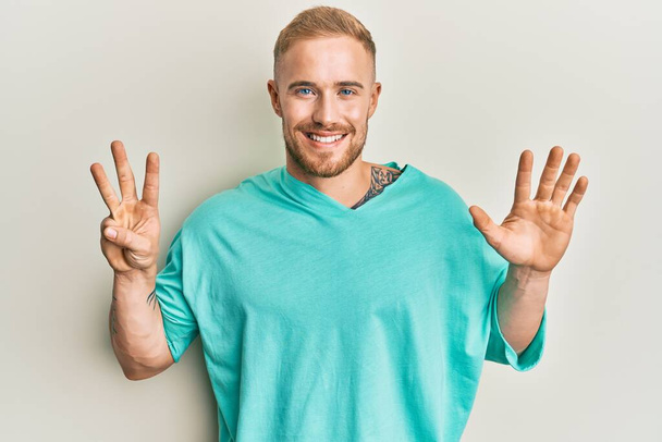 Young caucasian man wearing casual clothes showing and pointing up with fingers number eight while smiling confident and happy.  - Photo, Image