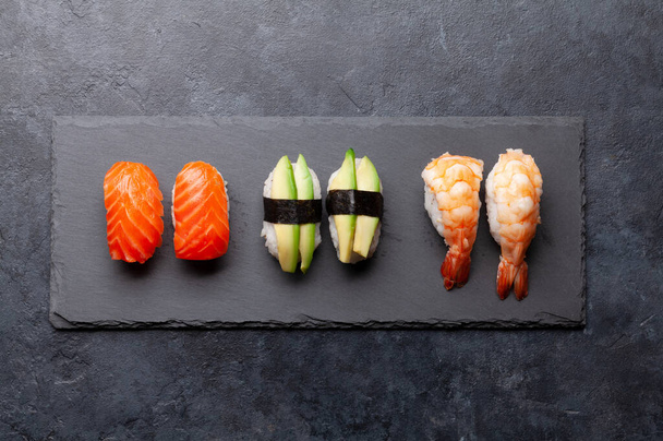 Japońskie sushi na kamiennym talerzu. Widok z góry płaski lay - Zdjęcie, obraz