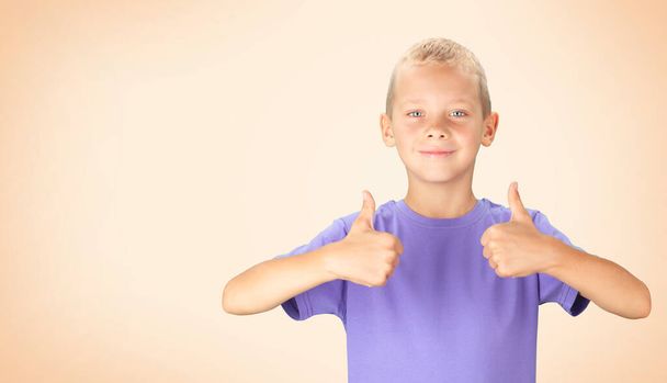 Funny boy showing thumbs up. Over color background with copy space - 写真・画像