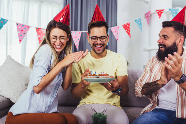 Grupo de pessoas felizes comemorando aniversário entre amigos e sorrindo enquanto fazem uma festa - Foto, Imagem