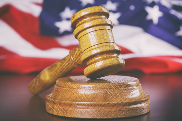Sędziowie drewniany młotek z flagą USA w tle - Zdjęcie, obraz