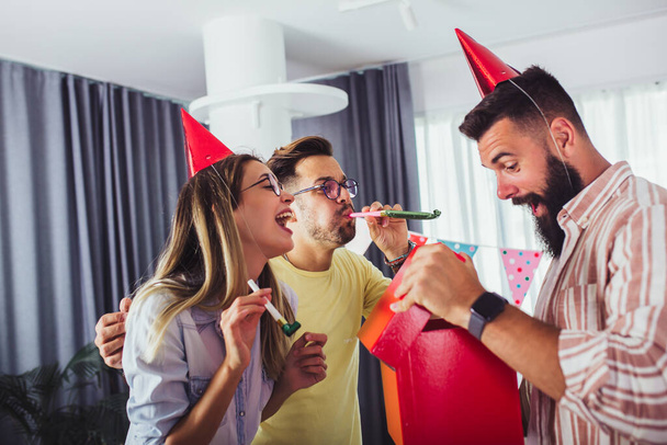 Egy csoport boldog ember ünnepli születésnapját barátok között és mosolyog, miközben egy party - Fotó, kép