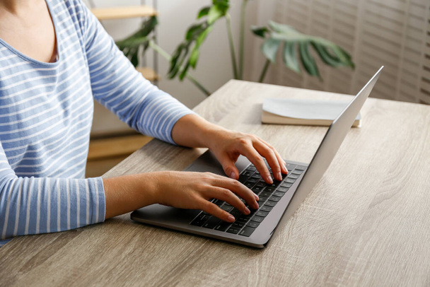 Work from home concept. Cropped shot of woman's hands typing on laptop. Female freelancer working at her living room. Close up, copy space for text. - Photo, image