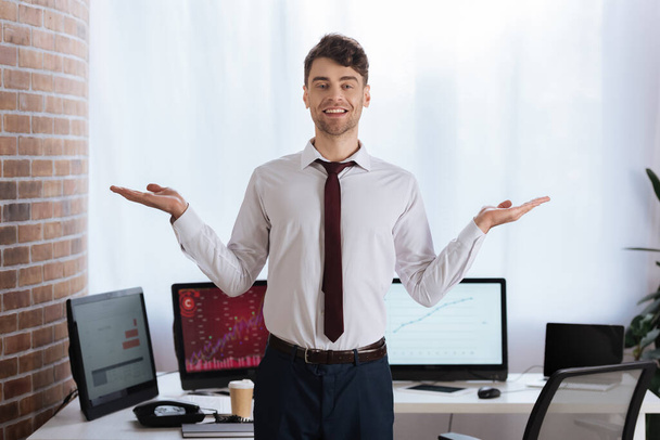 Positive businessman pointing with hands in office  - Фото, зображення
