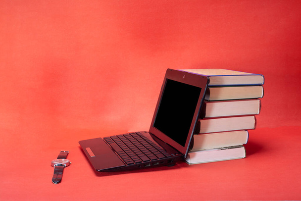 laptop and stack of books on yellow background - 写真・画像
