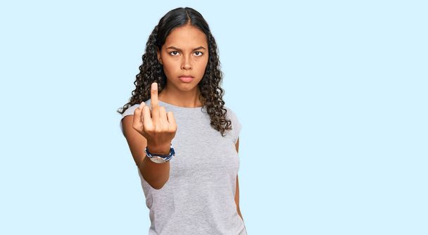 junge afrikanisch-amerikanische Mädchen in lässiger Kleidung zeigt Mittelfinger, unhöflich und unhöflich fuck off Ausdruck  - Foto, Bild