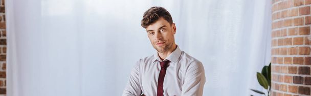 Young businessman looking at camera in office, banner - Fotografie, Obrázek