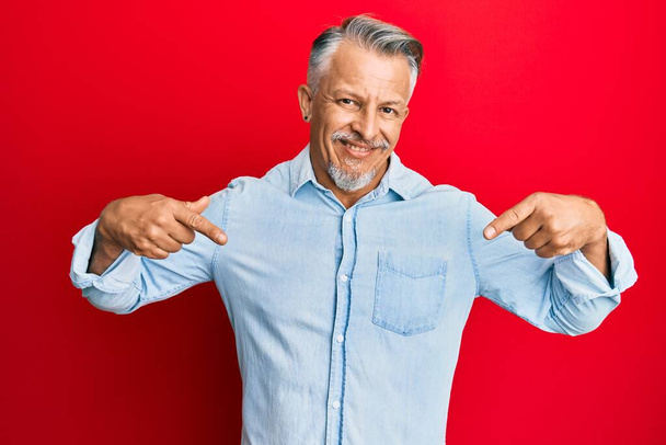 Hombre de pelo gris de mediana edad vistiendo ropa casual que se ve confiado con sonrisa en la cara, señalándose con los dedos orgullosos y felices.  - Foto, Imagen