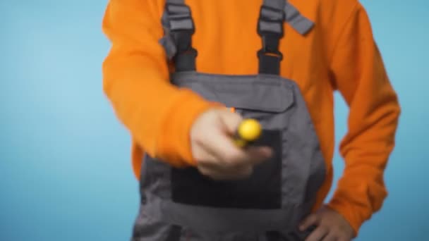 Ремонтник в промисловому робочому одязі, що віддає жовту викрутку
 - Кадри, відео