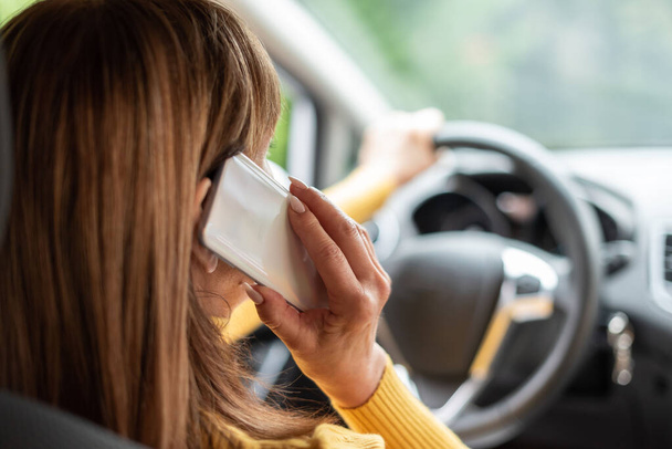 Γυναίκα μιλάει στο κινητό τηλέφωνο κατά την οδήγηση - Φωτογραφία, εικόνα