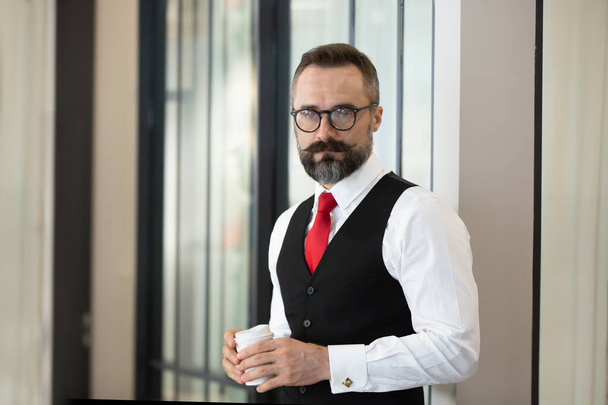 Bearded hipster businessman holding coffee cup portraits. - 写真・画像