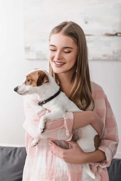 cheerful young woman holding in arms jack russell terrier - Fotoğraf, Görsel