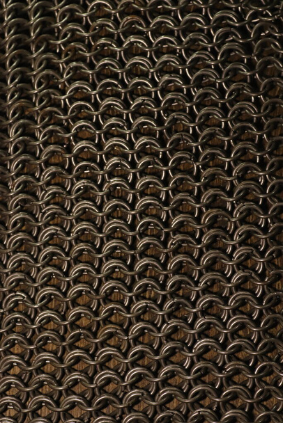tela de malla de cadena, anillos de acero en la superficie de madera - Foto, imagen