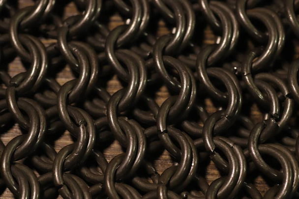 chaîne tissu de courrier, anneaux en acier sur la surface du bois - Photo, image
