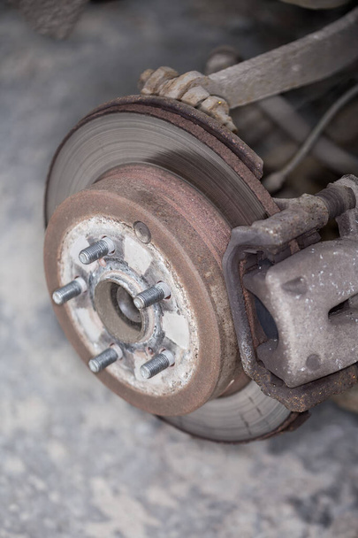 Задняя сборка дискового тормоза и колесного узла на подержанном автомобиле, вид с удаленным колесом крупным планом в селективном фокусе - Фото, изображение