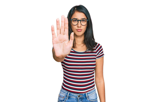 Beautiful asian young woman wearing casual clothes and glasses doing stop sing with palm of the hand. warning expression with negative and serious gesture on the face.  - Zdjęcie, obraz