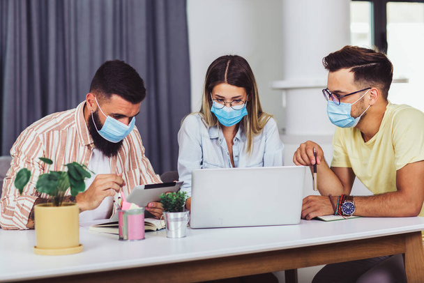 Students studies at home, wear protective masks, and using laptop - Φωτογραφία, εικόνα