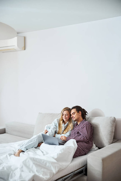 Gyönyörű boldog pár segítségével modern laptop otthon - Fotó, kép