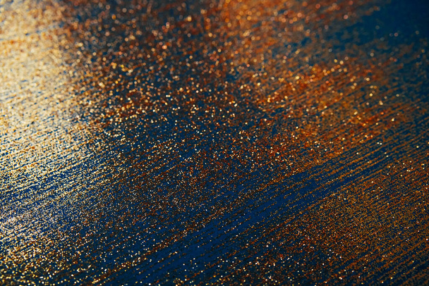 Gold glitter on dark blue bokeh abstract light defocused background. - Photo, Image