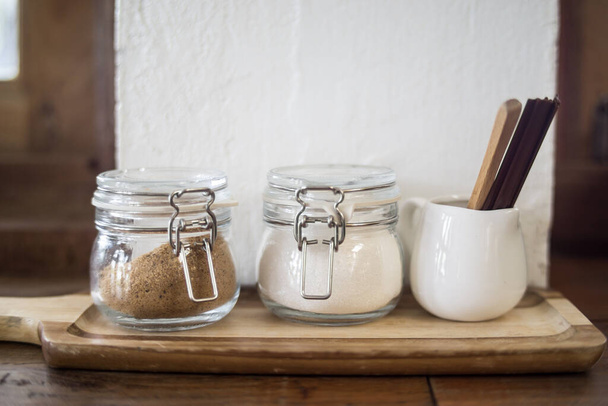 jars with different kinds of sugar and wooden sticks  on wooden table - Photo, Image