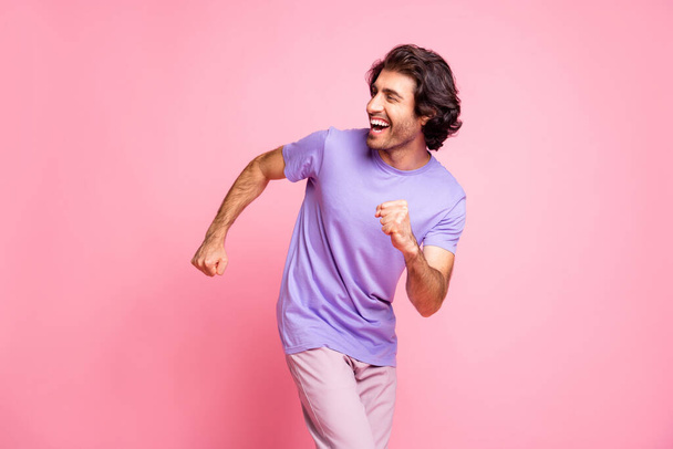 Photo of handsome club dancer arms fist happiness purple t-shirt isolated on pastel pink color background - Fotoğraf, Görsel