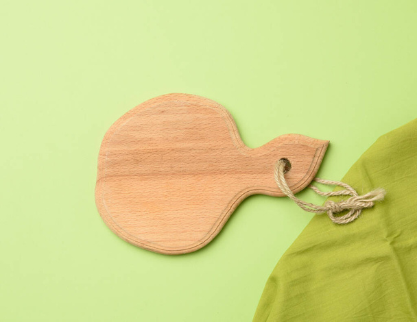 empty round wooden board on a  green background, top view - Foto, imagen