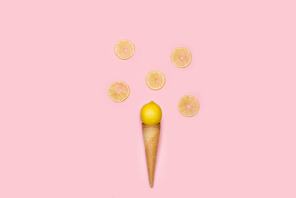 Oplatkový kornout s citronem a plátky citronu na růžovém pozadí - Fotografie, Obrázek
