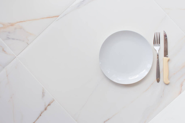 Empty ceramics plate isolated on white marble background. Copy space. Menu Recipe Concept - Fotó, kép