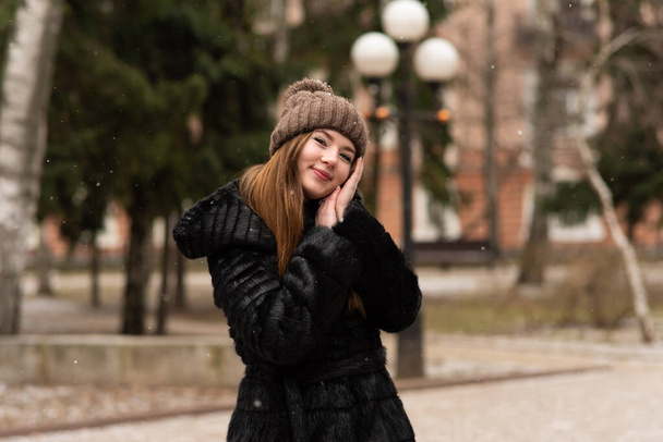 Outdoor portrait of beautiful happy smiling young woman posing on street. Lady wearing stylish winter clothes. Winter lifestyle - Фото, изображение